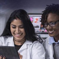 Two women researchers looking at a computer tablet